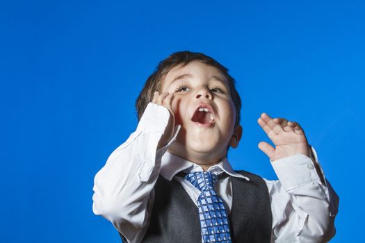 Leader, cute little boy portrait over blue chroma background