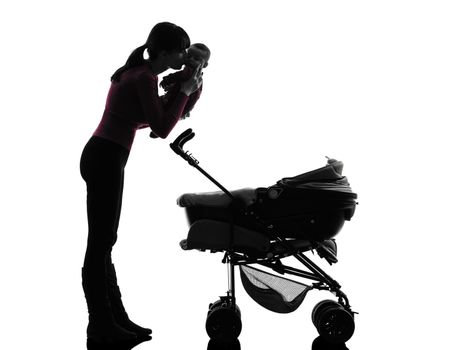 one caucasian woman prams holding baby kissing silhouette on white background