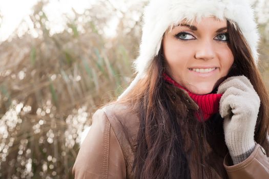 Happy brunette is having a nice time in the park while it's autumn