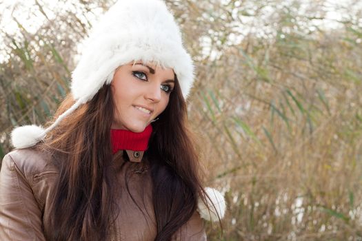 Happy brunette is having a nice time in the park while it's autumn