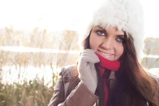 Happy brunette is having a nice time in the park while it's autumn