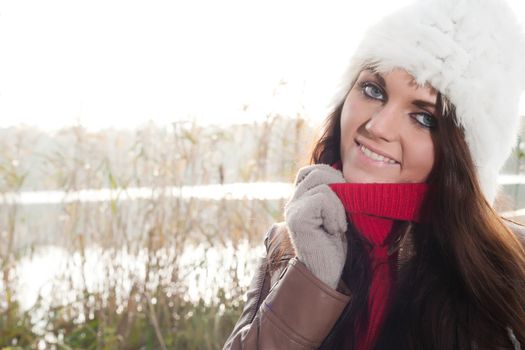 Happy brunette is having a nice time in the park while it's autumn