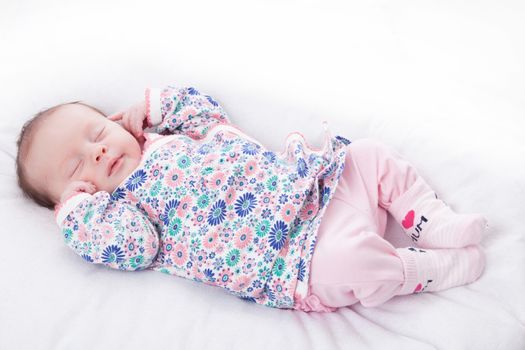 happy newborn baby girl just a week old photographed in the studio