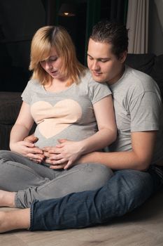Young couple is waiting for their first child in the living room