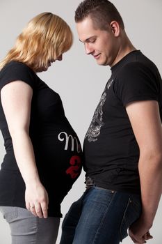 Happy young pregnant couple in the studio