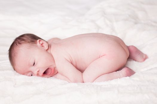 happy newborn baby girl just a week old photographed in the studio