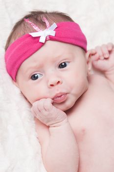 happy newborn baby girl just a week old photographed in the studio