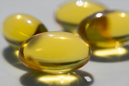 Macro to a yellow pills with a blue background.