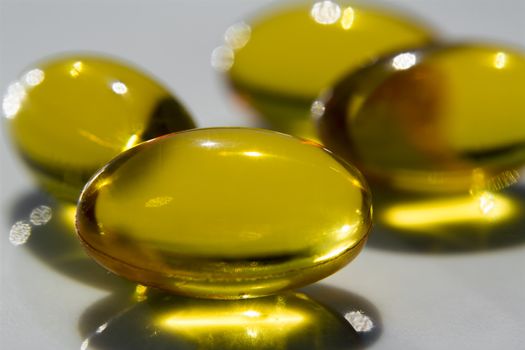 Macro to a yellow pills with a blue background.