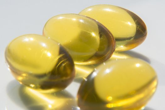 Macro to a yellow pills with a blue background.