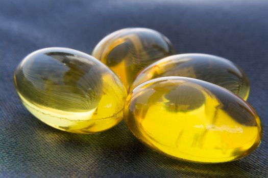 Macro to a yellow pills with a blue background.