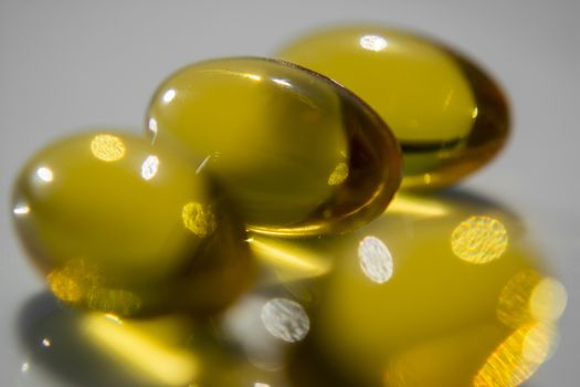 Macro to a yellow pills with a blue background.