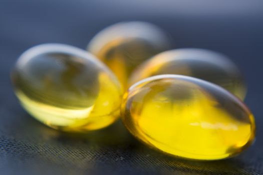 Macro to a yellow pills with a blue background.