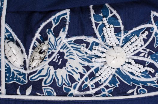 Embroidered  flower shaped bead pattern on   blue fabric