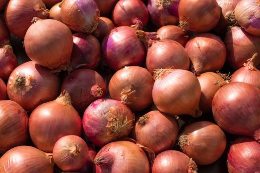 Full frame take of red onions on  a street market stall