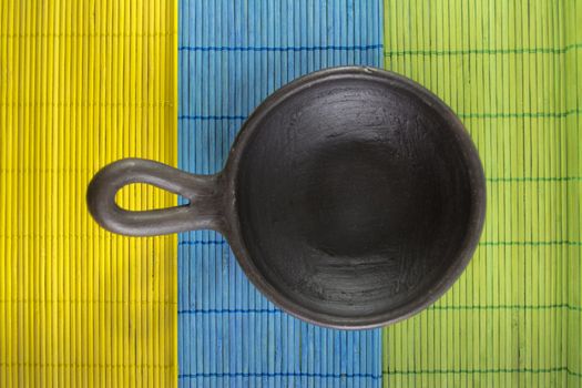 Mexican Oaxaca pottery bowl brown color on tablecloth made of wooden branches.