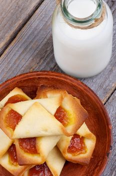 Homemade Pastry Jam Wrapped and Bottle of Milk closeup on Rustic Wooden background. Top View