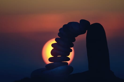 Pile of pebbles balancing on sky background