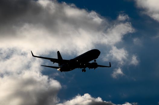 Silhouette of an Airplane Landing over a evening sky