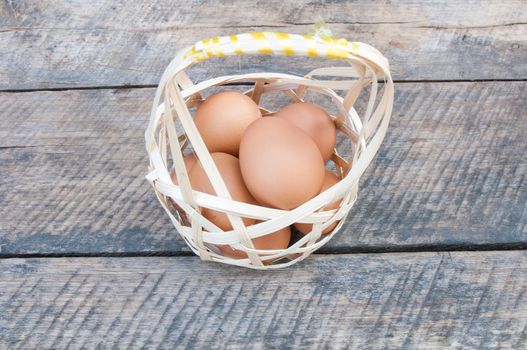 Eggs in basket  and wood on background