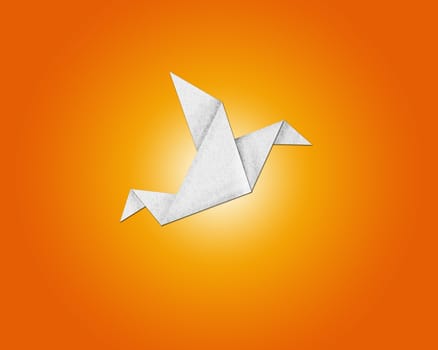 origami bird made of paper on orange background