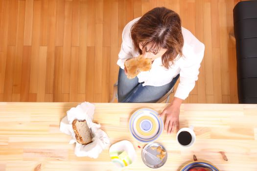 Portrait of a beautiful mature woman sitting in the kitchen. 