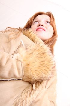 A attractive young, redhead woman in Winter clothing.