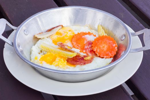fried eggs with extra Ingredients in aluminium pan in Thai style