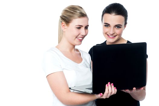 Two female college students working on a laptop computer 