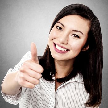 Pretty young girl showing thumbs up gesture