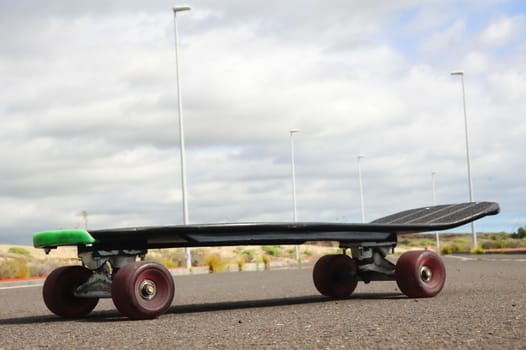 Vintage Style Longboard Black Skateboard on an Empty Asphalt Desert Road