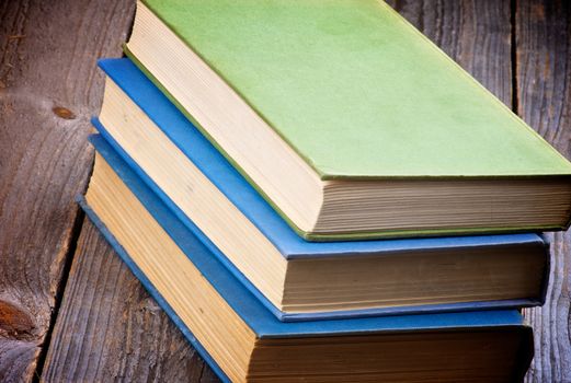 Pile of Three Old Books isolated on Rustic Wooden background