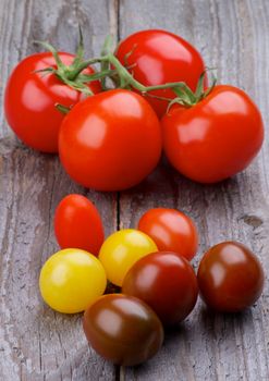 Arrangement of Various Ripe Red and Colorful Cherry Tomatoes isolated on Rustic Wooden background