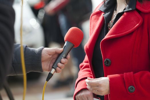 A journalist is making a interview with a microphone