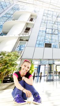 young casual female sitting on the ground with a glass, smiling, background added digitally, work path