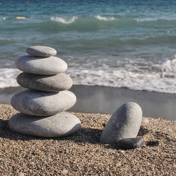 Stack of stones on the beach of blue sea