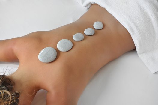 young woman in a spa having hot stones treatment