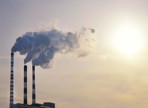 industrial smoke from chimney on blue sky