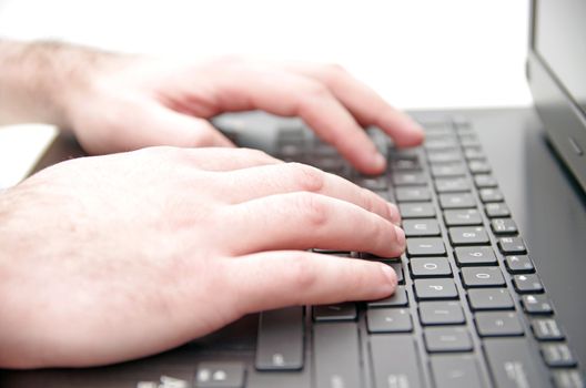 Hands typing on a laptop keyboard