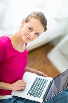 Pretty, young woman working on her laptop computer (shallow DOF; color toned image)