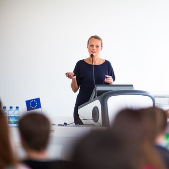 Pretty, young business woman giving a presentation in a conference/meeting setting (shallow DOF; color toned image)