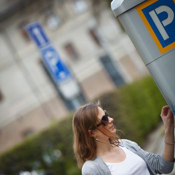 Young woman paying for parking