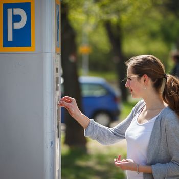 Young woman paying for parking