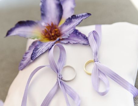 Wedding rings with flower on a white pad