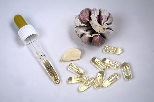 Glass dropper on capsules of garlic oil, Garlic oil capsules, vitamins d pills 