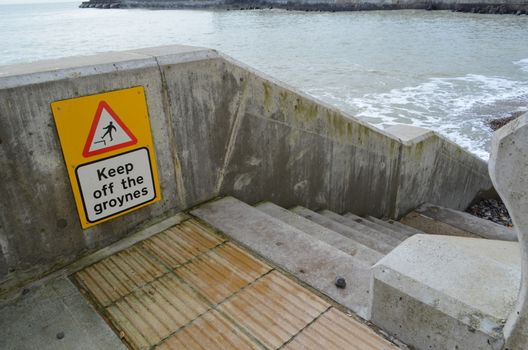 Warning sign informing the public to keep off the sea groyne.