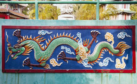 SINGAPORE - FEBRUARY 1, 2014: Colorful Dragon Wall Relief Sculpture at Haw Par Villa Theme Park. This theme park contains over 1,000 statues and 150 giant dioramas depicting scenes from Chinese mythology, folklore, legends, and history.