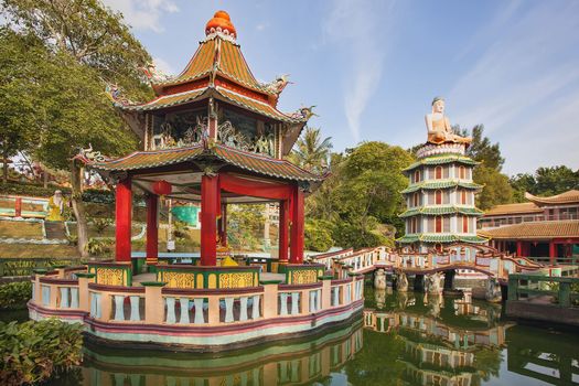 SINGAPORE - FEBRUARY 1, 2014: Chinese Pagoda and Pavilion by the Lake at Haw Par Villa Theme Park. This theme park contains over 1,000 statues and 150 giant dioramas depicting scenes from Chinese mythology, folklore, legends, and history.