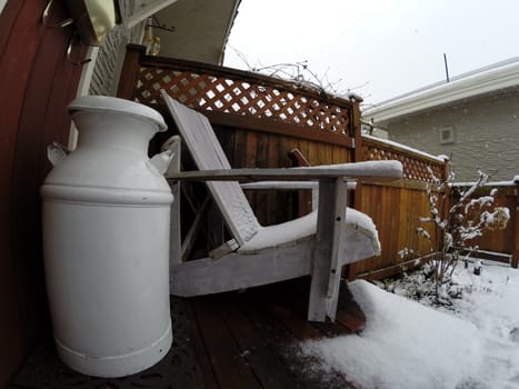 Adirondack chair and milk can in the snow