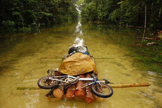 Folding bycicle at raft flooded gravel road, Papua New Guinea